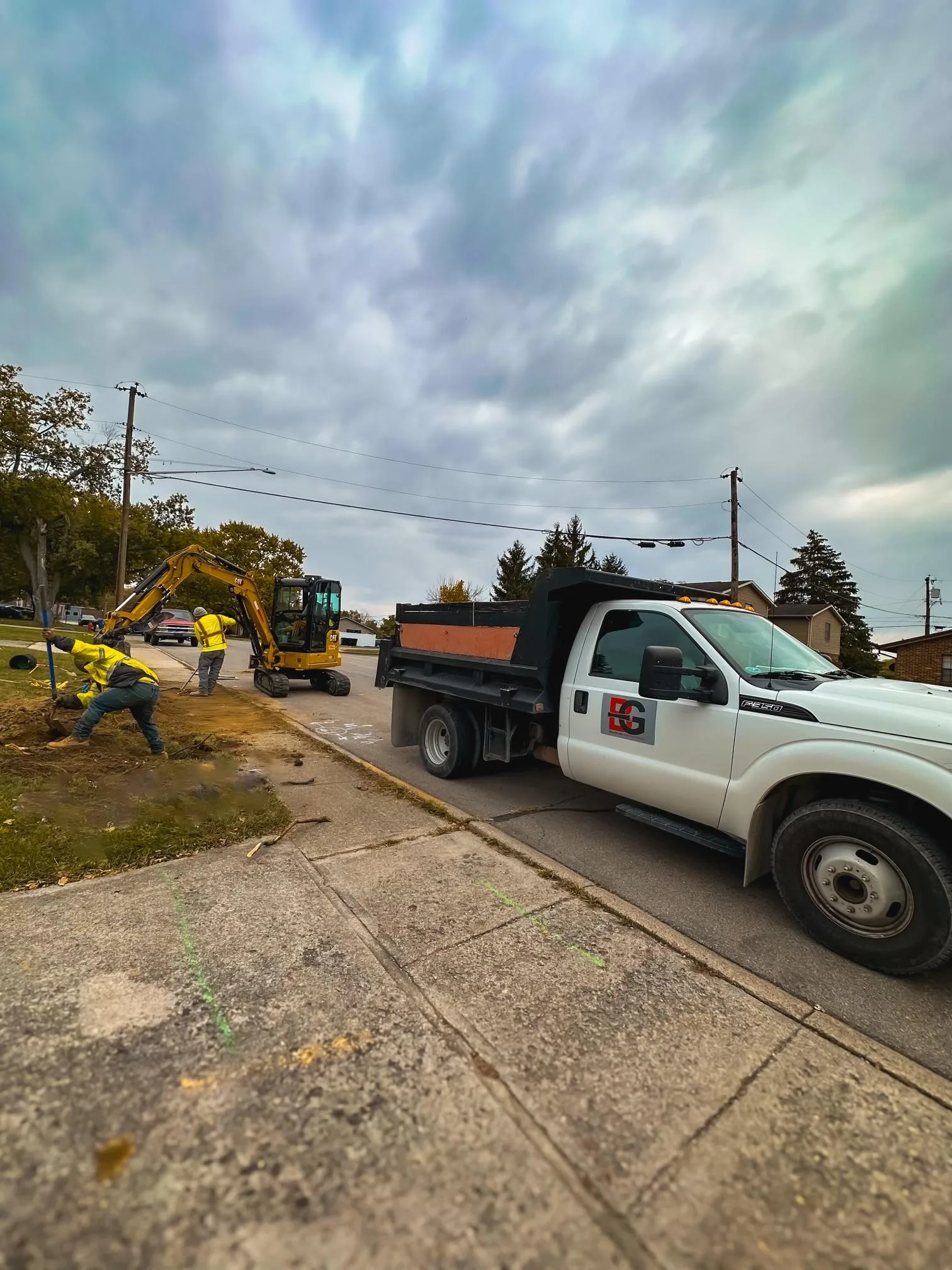 Mini excavator and B&G dump truck on a residential site